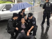8旬老人雨中摔倒受伤不起 民警举盾牌为他遮雨