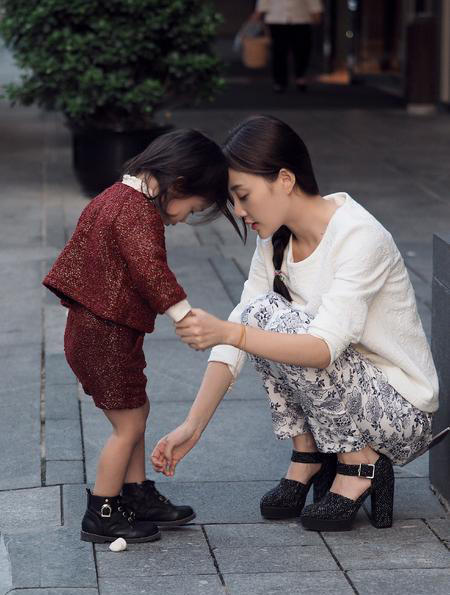 李小璐蹲在街头为女儿系鞋带