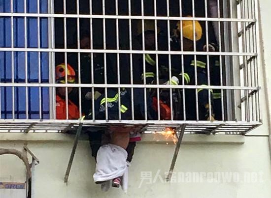 两岁女童被防盗网卡住，身体悬空。