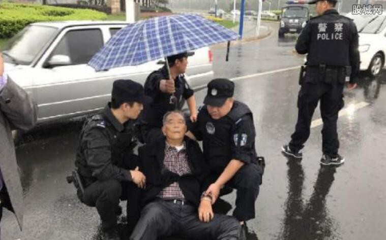 民警举盾牌为老人遮雨